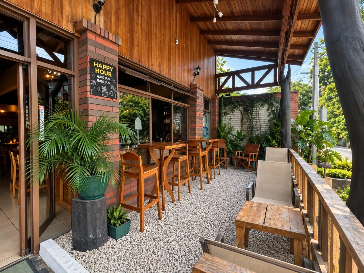 Don Luis terrace with tall wooden tables, plants and the Happy Hour sign